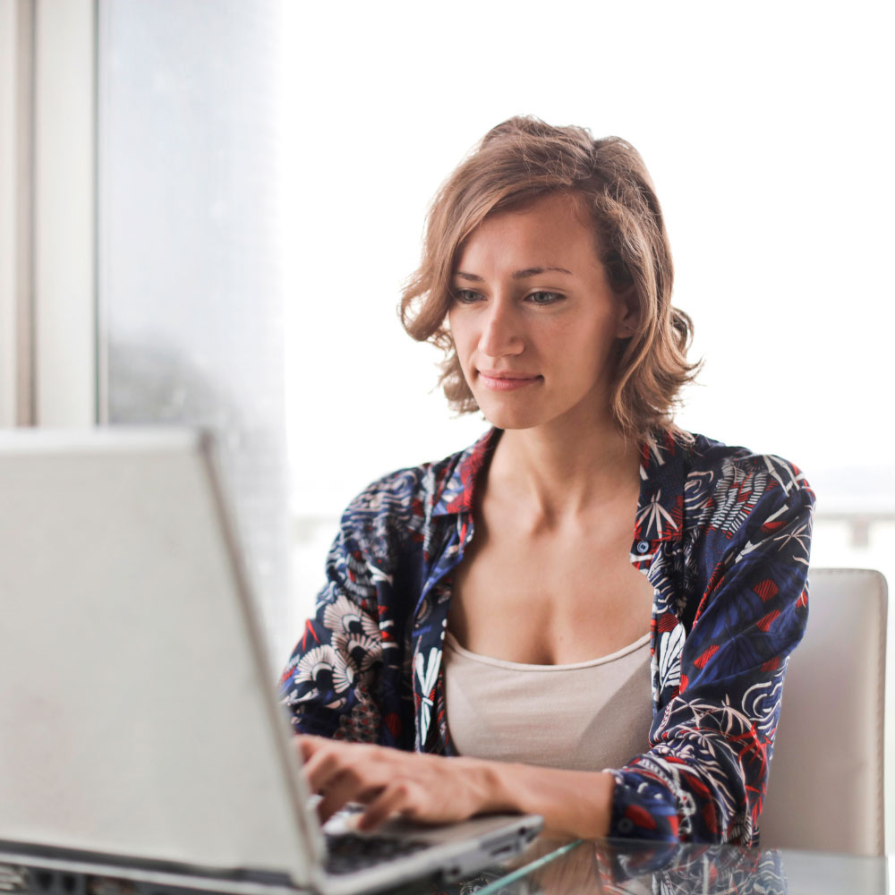 Woman following online training course on laptop.