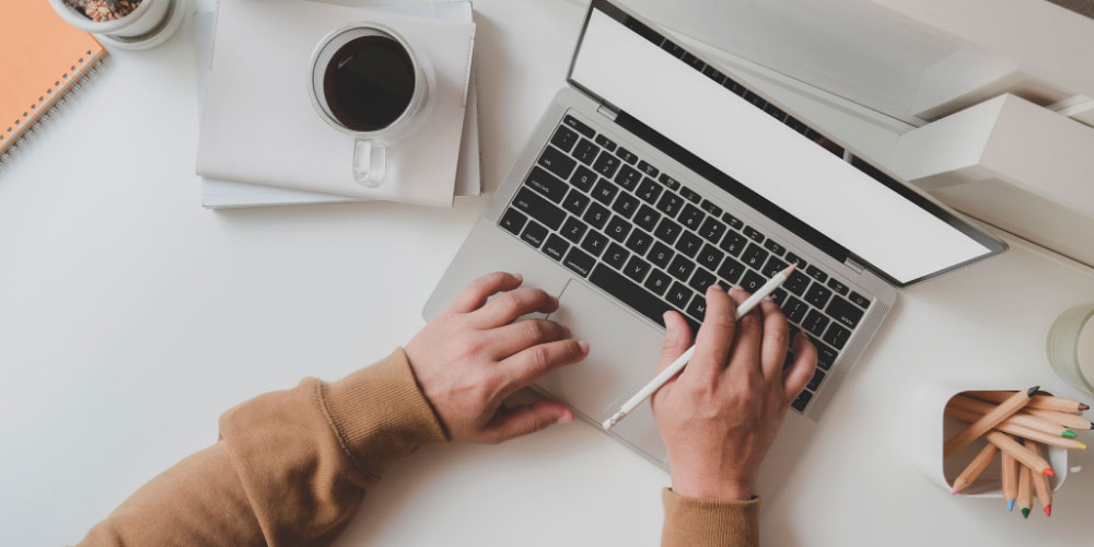 Person learning online with laptop and coffee.