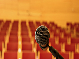 Microphone in empty lecture hall, presenting context.